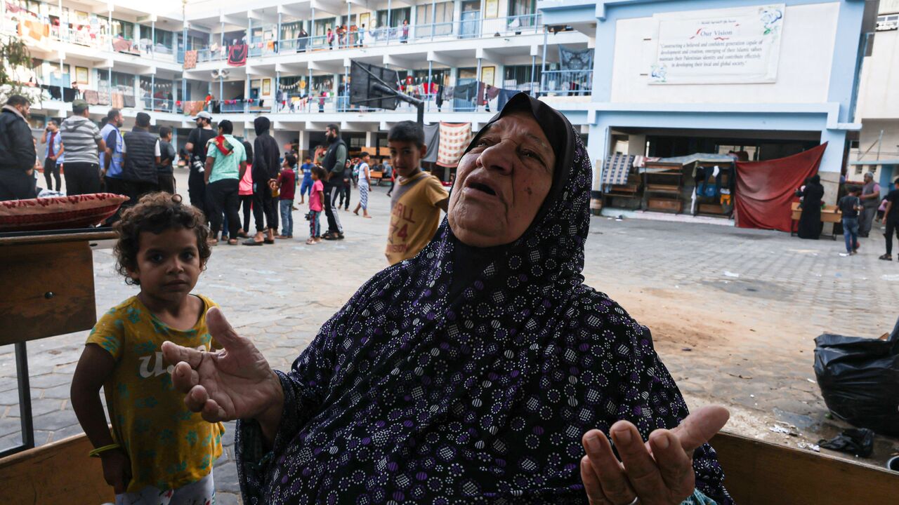 EDITORS NOTE: Graphic content / A Palestinian woman looks up as she prays in the yard of a school, in the Rafah refugee camp, in the southern of Gaza Strip on October 14, 2023, as fighting between Israel and the Hamas movement continues for the eighth consecutive day in the Gaza Strip enclave. Palestinians sought refuge on October 14, 2023, after Israel warned them to evacuate the northern Gaza Strip before an expected ground offensive against Hamas, one week after the deadliest attack in Israel's history. 