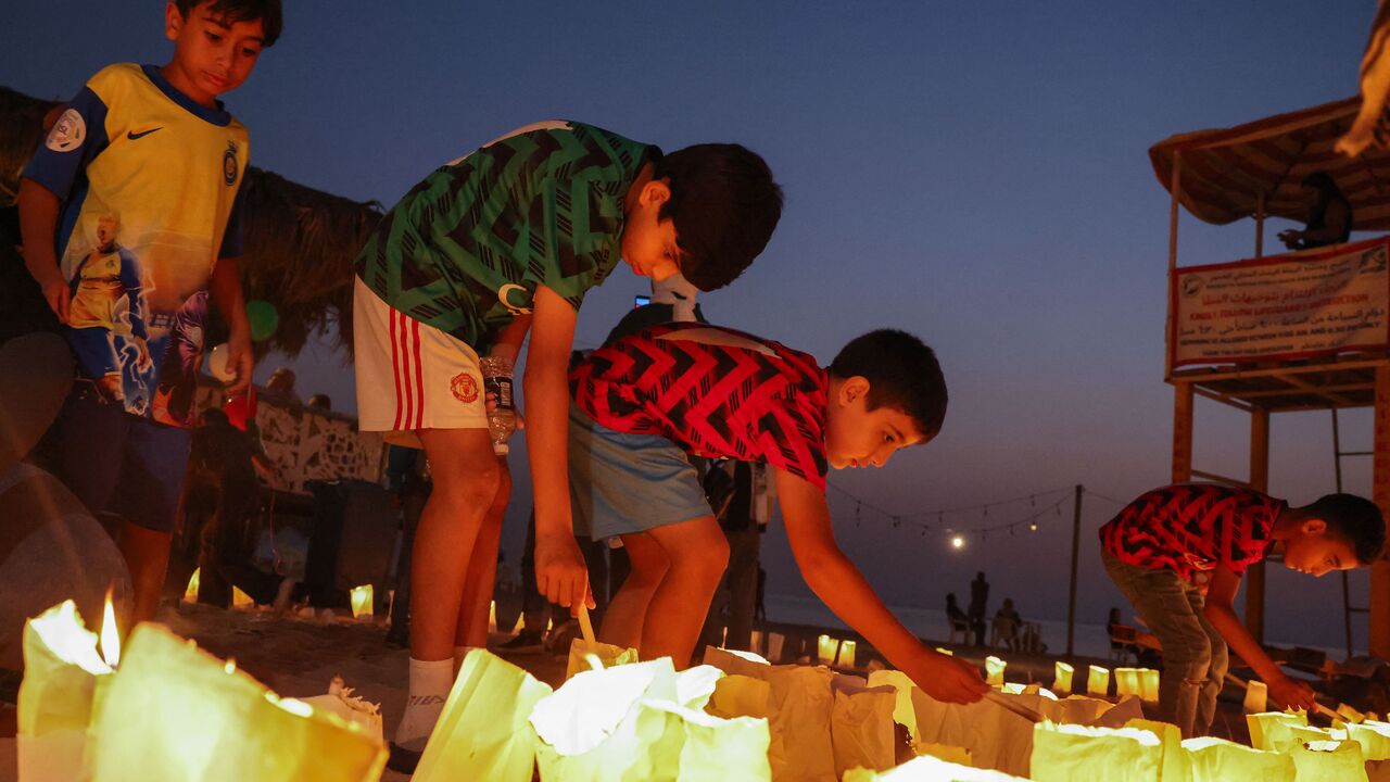 Children light candles during a solidarity vigil organized by Lebanon's Press Photographers Syndicate and the Ajial Social Communication Center, at the Ramlet al-Bayda beach in Beirut on October 22, 2023 in memory of killed Lebanese Journalist Issam Abdallah and in support of Palestinians amid the the ongoing battles between Israel and the Palestinian group Hamas in the Gaza Strip. (Photo by JOSEPH EID / AFP) (Photo by JOSEPH EID/AFP via Getty Images)