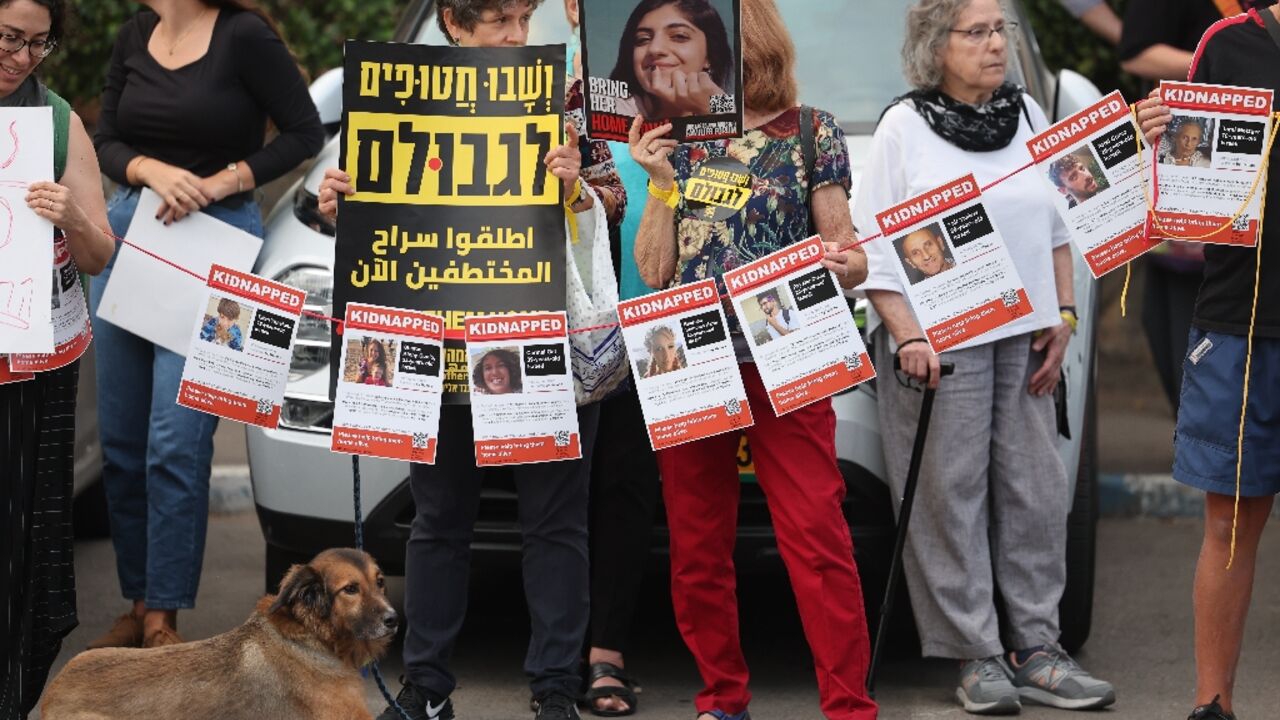 Demonstrators carry posters with the images of hostages held in Gaza outside the Israeli president's residence in Jerusalem Demonstrators carry posters with the images of hostages held in Gaza outside the Israeli president's residence in Jerusalem