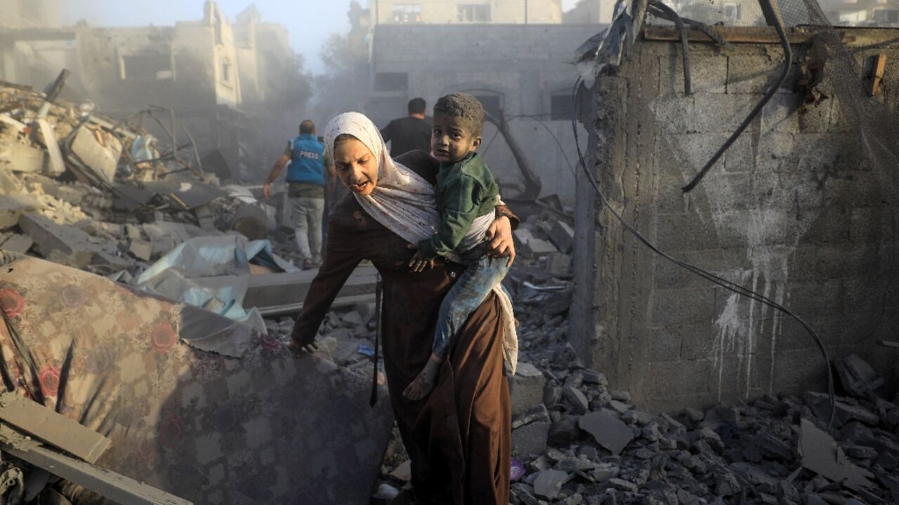 People flee following Israeli air strikes on a neighbourhood in the al-Maghazi refugee camp in the central Gaza Strip