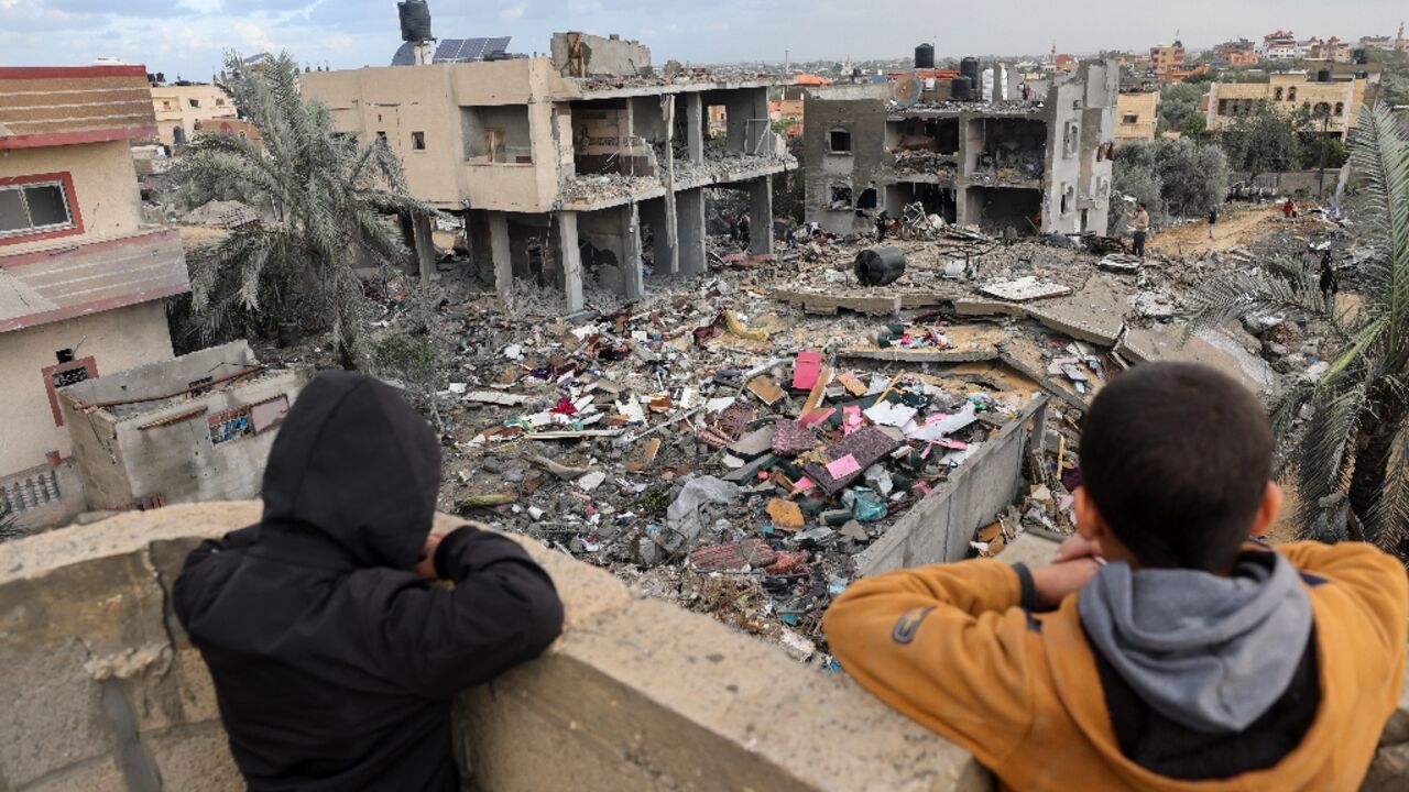 Palestinian children above the rubble of a building destroyed during Israeli strikes on Rafah, in the southern Gaza Strip