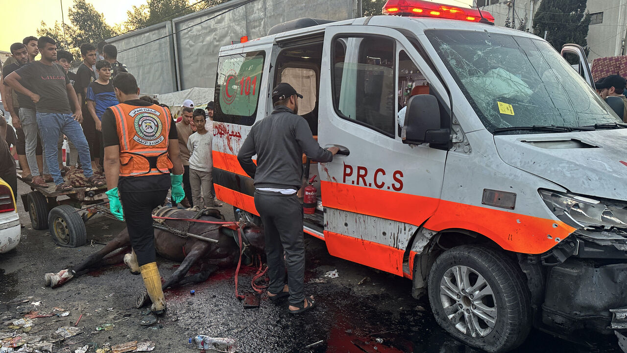 A dead horse lies on the ground as people gather around an ambulance damaged in a reported Israeli strike in front of Al-Shifa hospital in Gaza City on Nov. 3, 2023, as battles between Israel and the Palestinian Hamas movement continue.