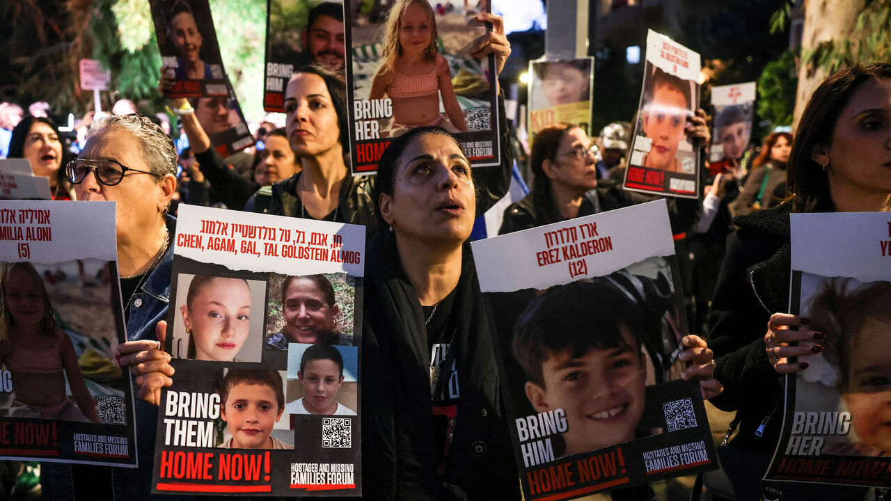 A woman holds portraits of hostages Erez Kalderon, 12, and of children of the Goldstein Almog family as protesters rally outside the UNICEF offices to demand the release of Israelis held hostage in the Gaza Strip since the Hamas attack Oct. 7, amid ongoing battles between Israel and the Palestinian armed group, Tel Aviv, Israel, Nov. 20, 2023.