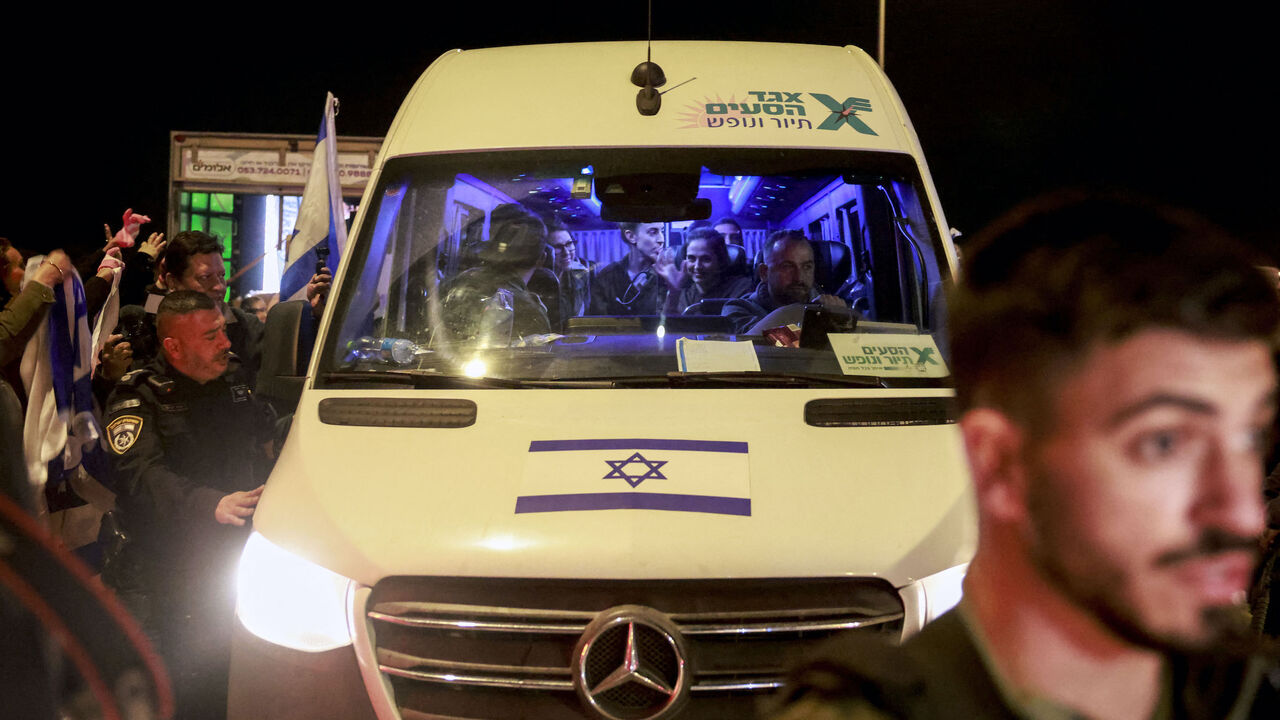 Newly release Israeli hostages sit among soldiers as they arrive inside a vehicle at Ofakim army base in southern Israel early on Nov. 30, 2023, after being freed from the Gaza Strip following the Oct. 7 attacks in Israel by the Palestinian militant group Hamas. 