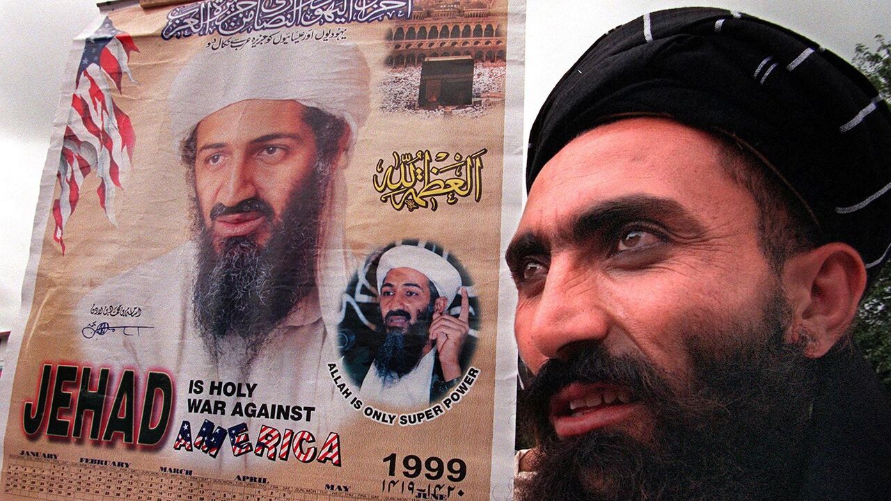 A religious protester holds a portrait of Saudi dissident Osama bin Laden during a protest rally against the United States on July 30, 1999, in Islamabad.