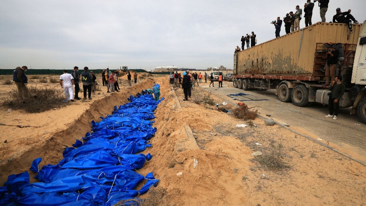 Dozens of blue-wrapped bodies are placed in a mass grave Dozens of blue-wrapped bodies are placed in a mass grave