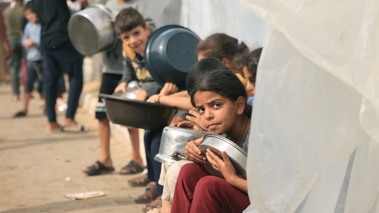 Displaced Palestinian children wait for food in Khan Yunis Displaced Palestinian children wait for food in Khan Yunis