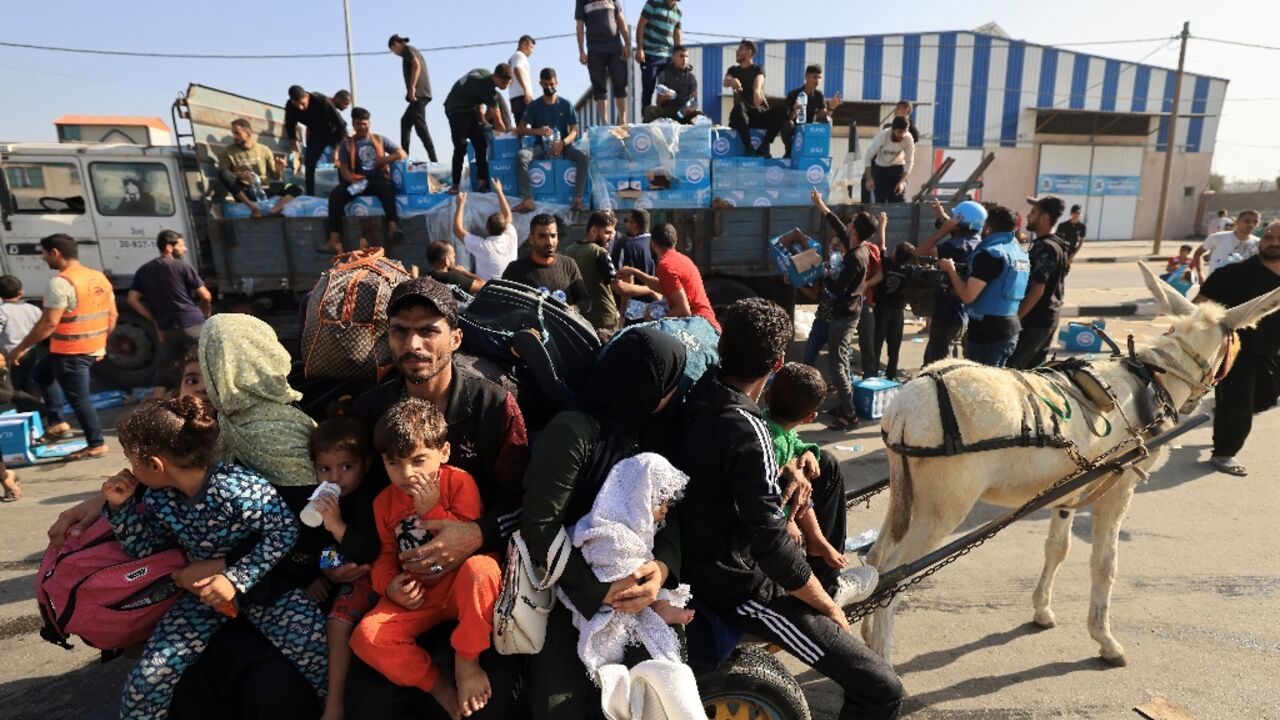 Bottles of water are handed out as Palestinians families flee northern Gaza amid the ongoing battles between Israel and the Palestinian Islamist group Hamas. 