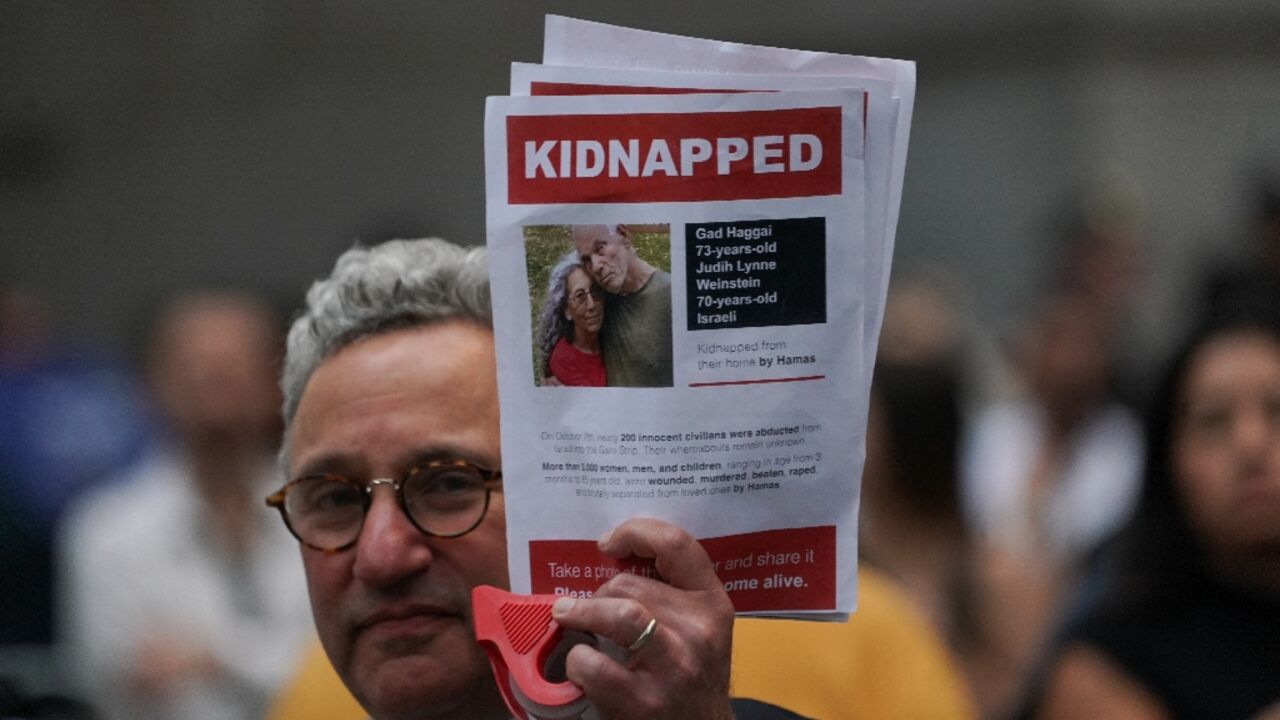 A man holds a picture of hostages Gad and Judith Weinstein Haggai -- both of whom have been confirmed killed -- during a New York rally on October 26, 2023 A man holds a picture of hostages Gad and Judith Weinstein Haggai -- both of whom have been confirmed killed -- during a New York rally on October 26, 2023