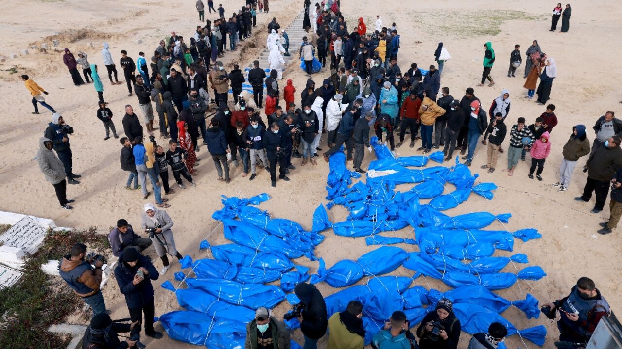 Palestinian health ministry staff prepare to bury dozens of unidentified Gazans in a mass grave after their bodies were exhumed then returned by Israel, according to Gaza officials