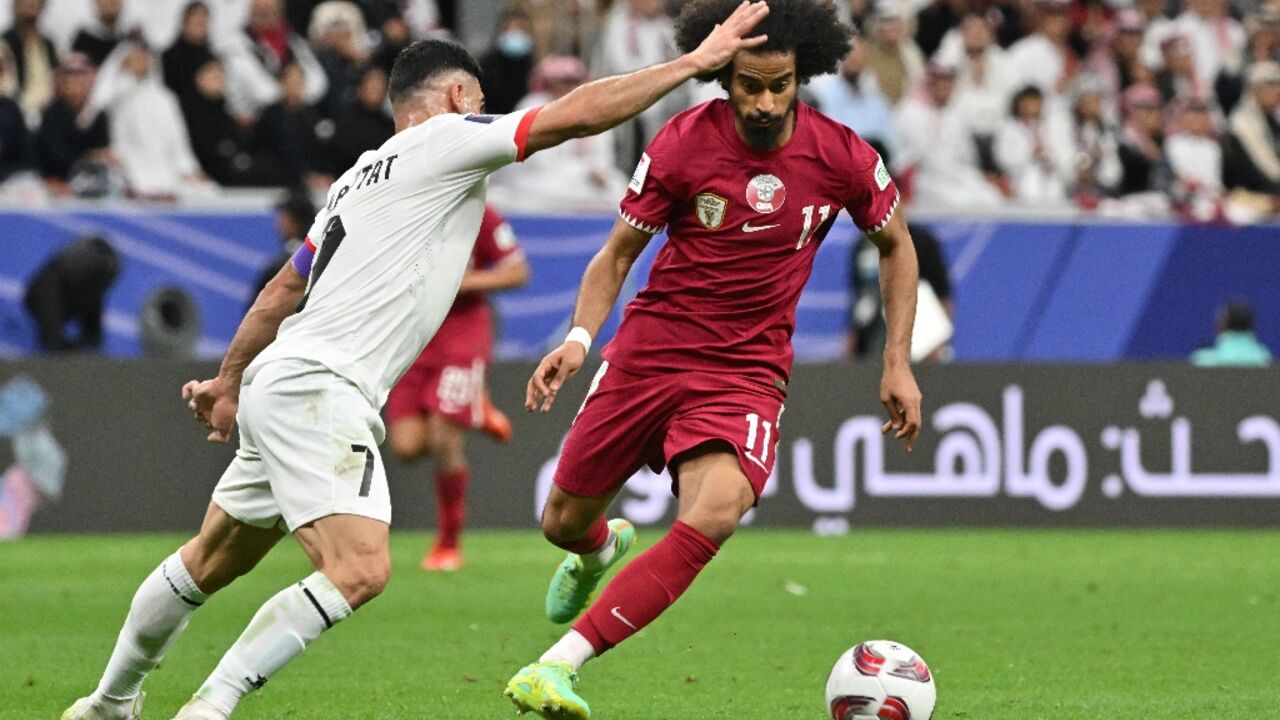 Qatar's forward #11 Akram Afif and Palestine's defender #07 Musab al-Battat during the match between Qatar and Palestine