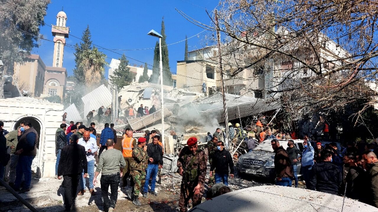 People and security forces gather in front of a building destroyed in a reported Israeli strike in Damascus on January 20