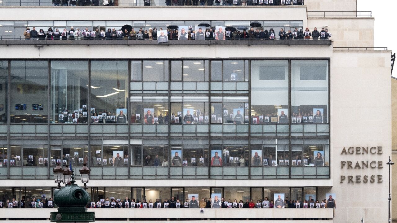 AFP journalists held up portraits of their colleagues in Gaza at the agency's Paris headquarters AFP journalists held up portraits of their colleagues in Gaza at the agency's Paris headquarters