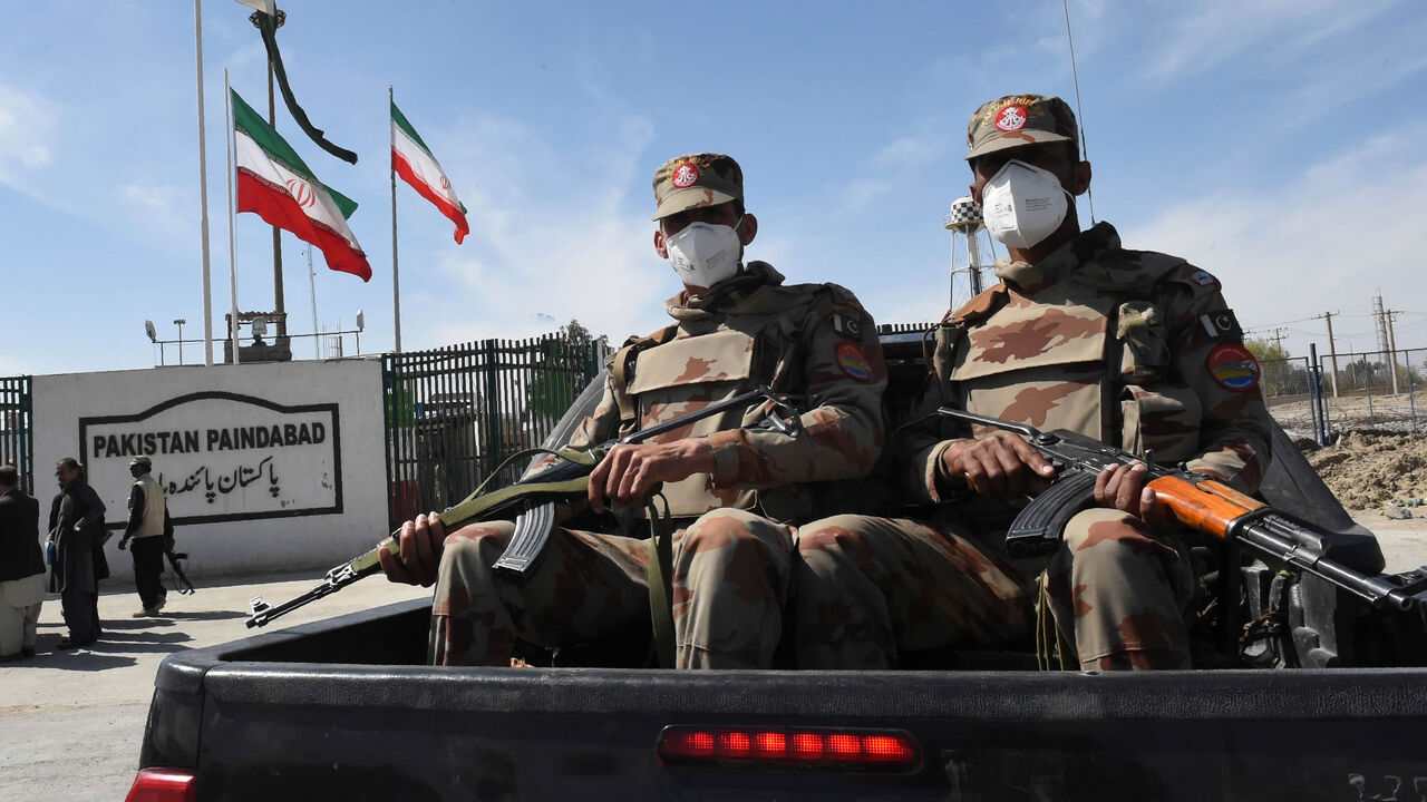 Pakistani soldiers wearing facemasks patrol near the closed Pakistan-Iran border in Taftan, as fears over the spread of the coronavirus escalate following an outbreak in neighboring Iran, Feb. 25, 2020.