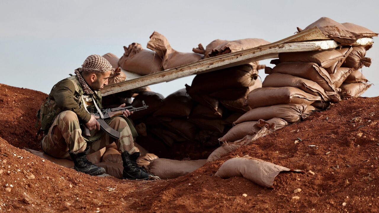 Turkey-backed Syrian fighter sits at a position on the outskirts of the town of Marea.