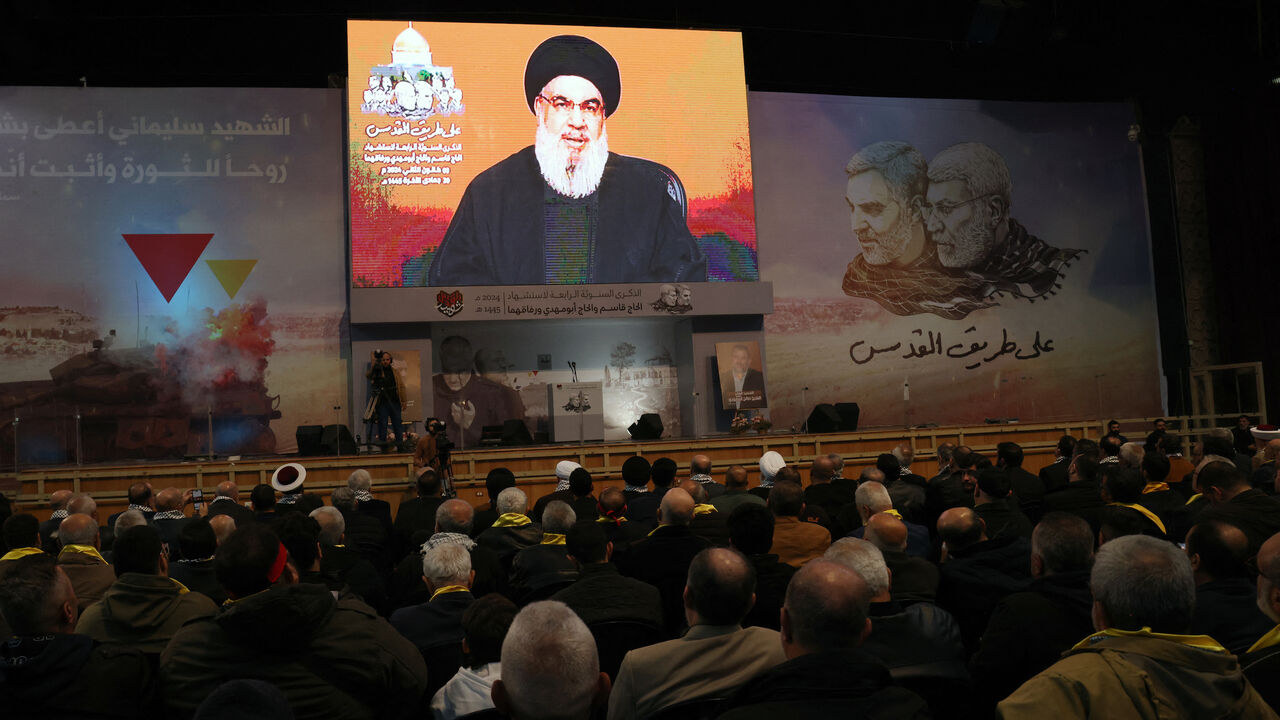 People watch the televised speech of Lebanon's Hezbollah chief Hasan Nasrallah to mark the anniversary of the killing of slain top Iranian commander Qasem Soleimani, in a Beirut's southern suburb on Jan. 3, 2024. 