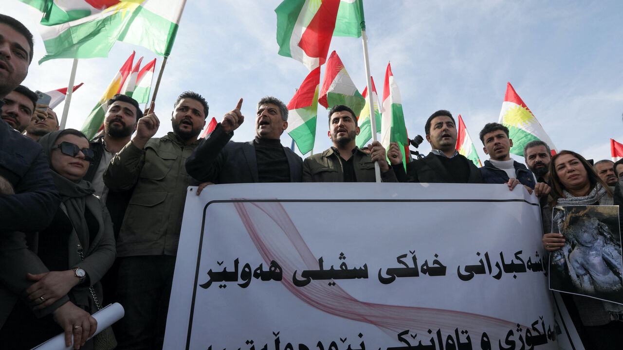 Protesters hold a banner and Kurdish flags during a demonstration outside the United Nations (UN) office, a day after several areas in the city were hit by a missile attack launched by Iran's Islamic Revolutionary Guard Corps (IRGC), in Erbil, the capital of Iraq's northern autonomous Kurdish region early on Jan. 16, 2024. 