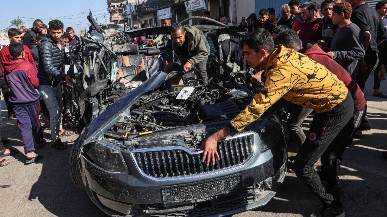 Crowds examine the car in which two journalists, Mustafa Thuria, a video stringer for AFP news agency, and Hamza Wael Dahdouh, a journalist with Al Jazeera television network, were killed in an air strike on Rafah blamed by Hamas on Israel
