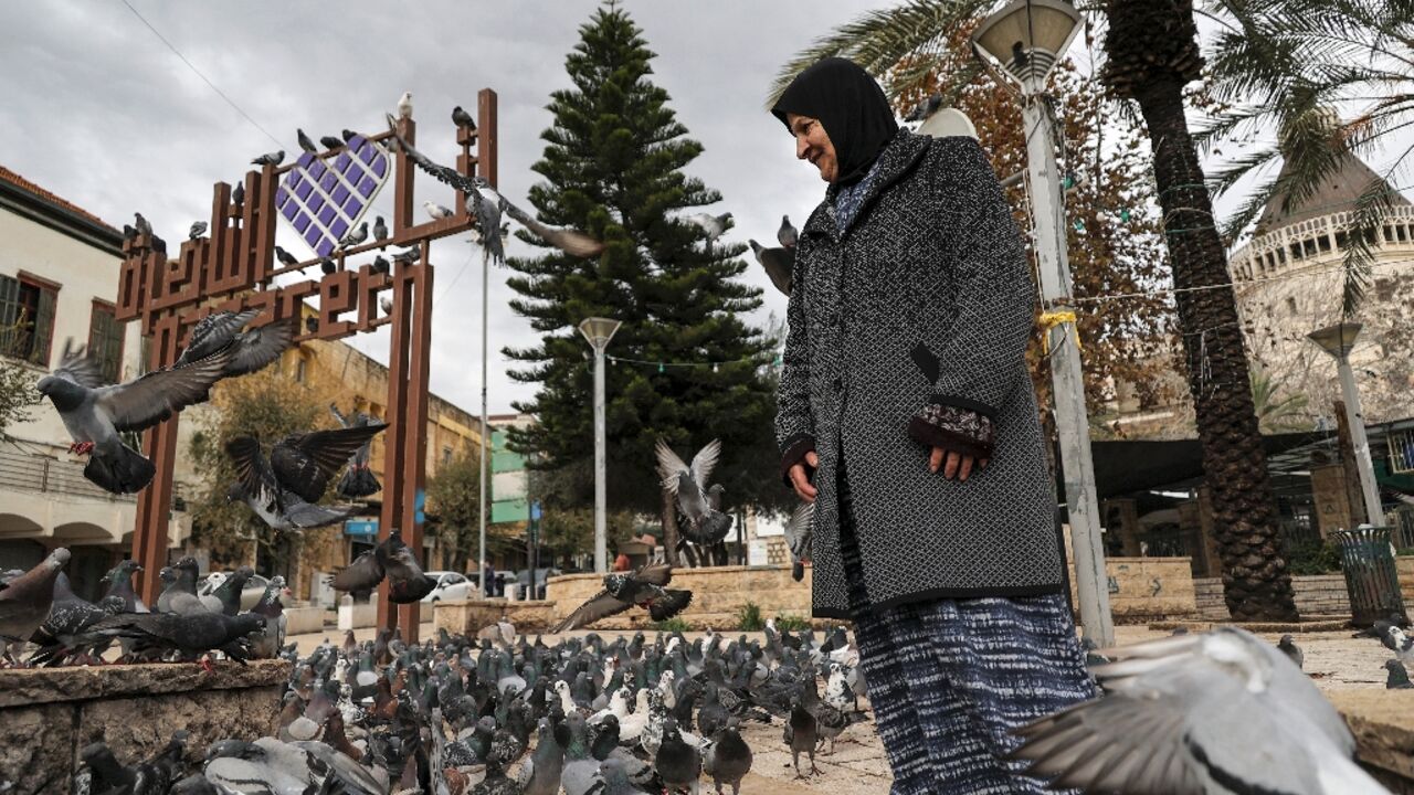 A woman stands among pigeons at the square outside the Roman Catholic Basilica of the Annunciation in Nazareth in northern Israel A woman stands among pigeons at the square outside the Roman Catholic Basilica of the Annunciation in Nazareth in northern Israel