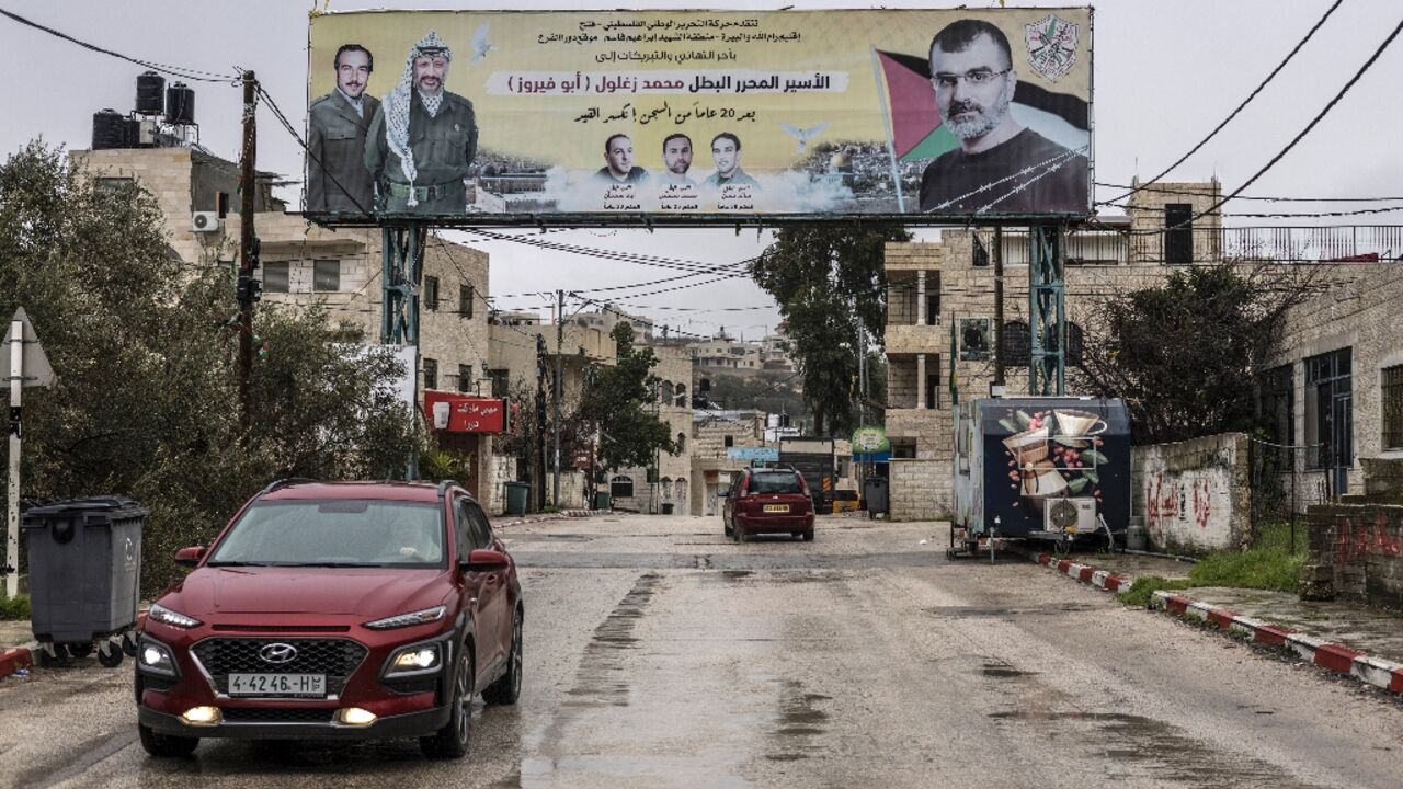 A poster depicting Palestinian prisoner Muhammad Zaghloul Hassan (R) and Palestinian leader Yasser Arafat is seen outside his family home A poster depicting Palestinian prisoner Muhammad Zaghloul Hassan (R) and Palestinian leader Yasser Arafat is seen outside his family home