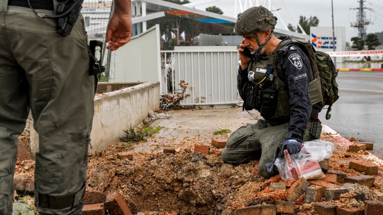 An Israeli policeman inspects the impact crater left by a rocket fired from southern Lebanon in the northern city of Safed An Israeli policeman inspects the impact crater left by a rocket fired from southern Lebanon in the northern city of Safed