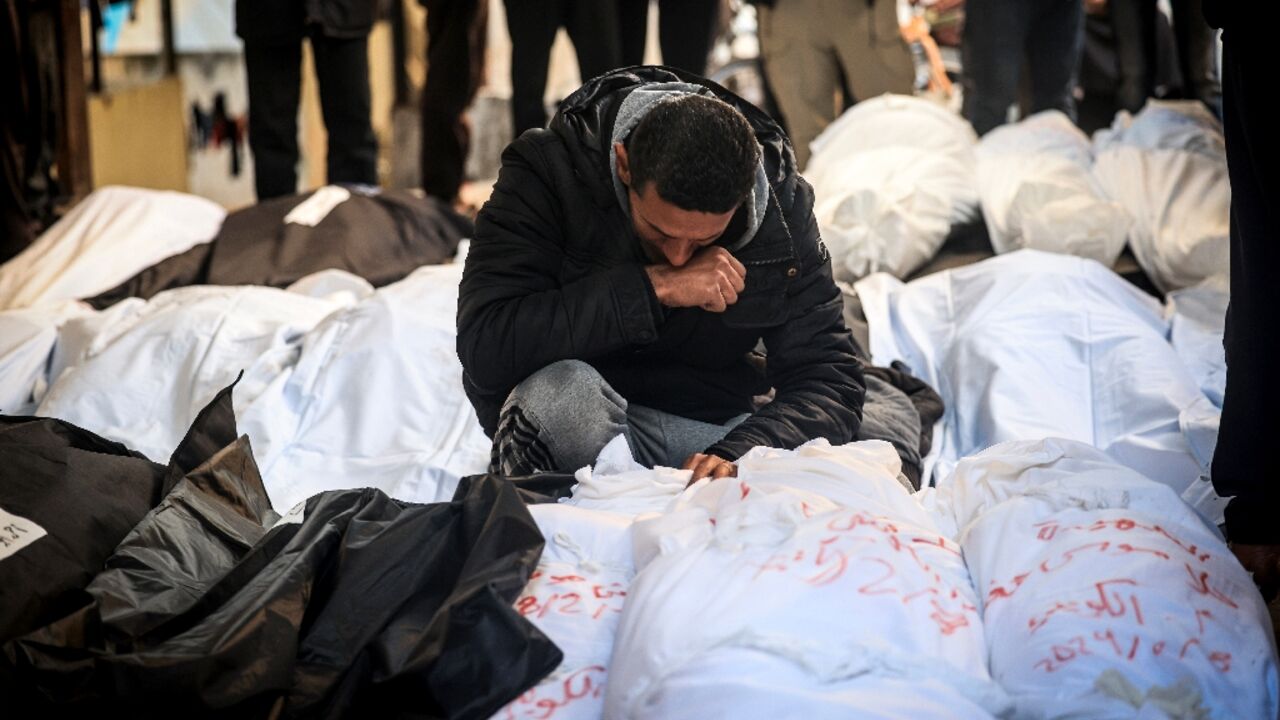 A Palestinian man mourns over shrouded bodies of relatives killed in overnight Israeli bombardment on the southern Gaza Strip at Al-Najjar hospital in Rafah on February 8, 2024 A Palestinian man mourns over shrouded bodies of relatives killed in overnight Israeli bombardment on the southern Gaza Strip at Al-Najjar hospital in Rafah on February 8, 2024