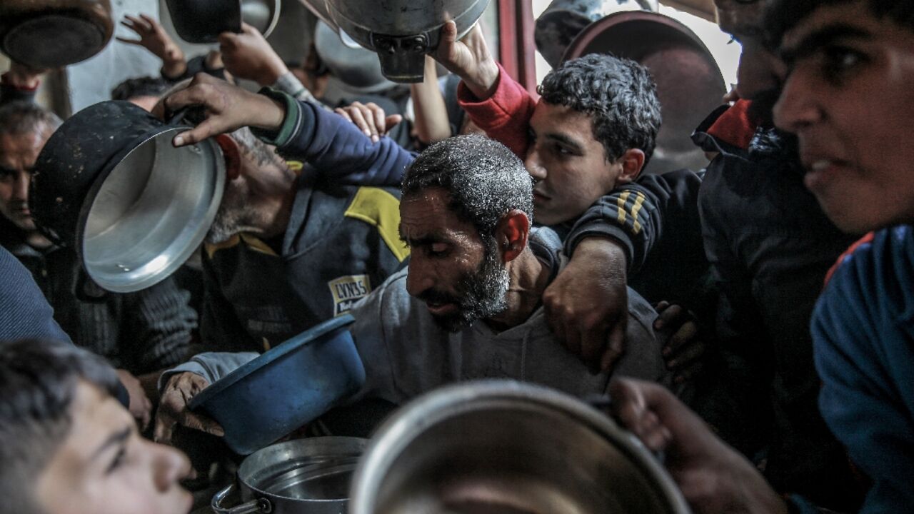 Palestinians collect aid food in Beit Lahia, in the northern Gaza Strip 