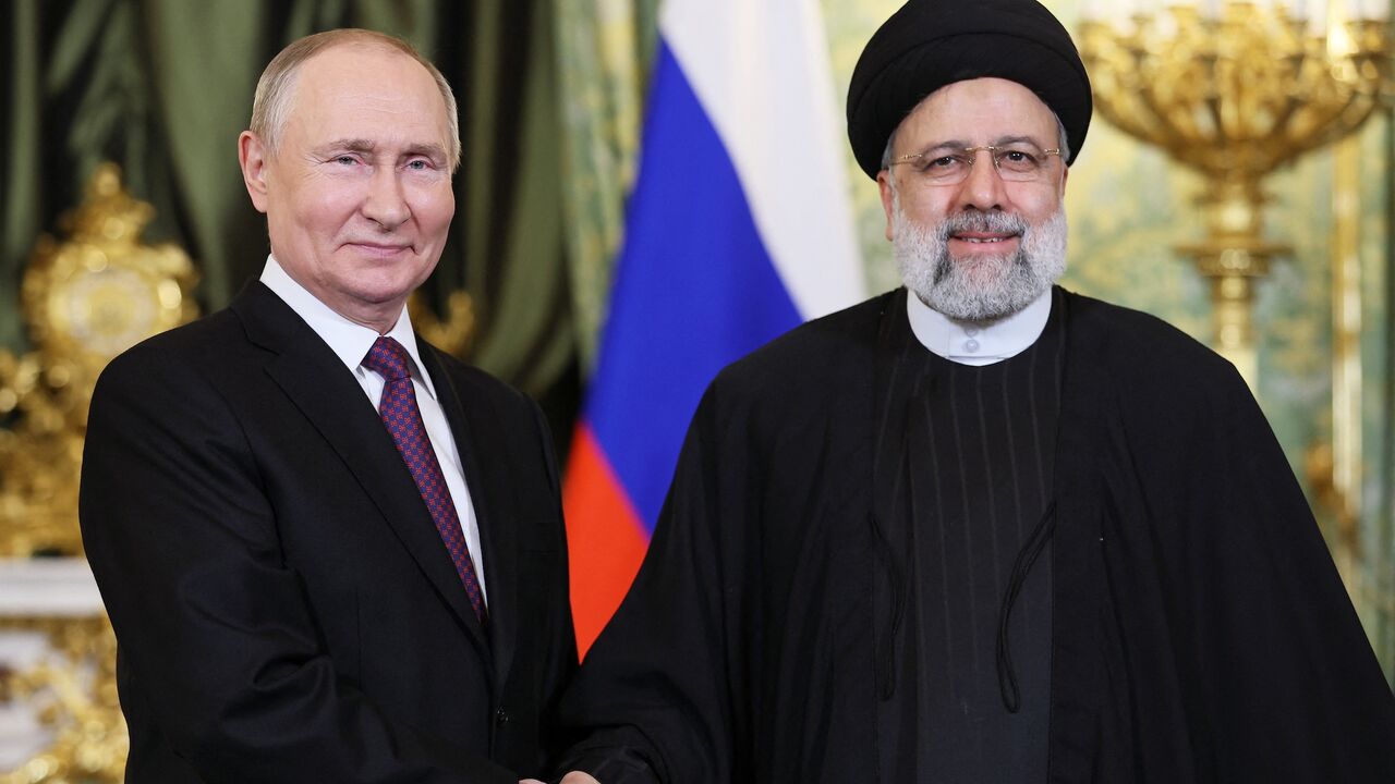 In this pool photograph distributed by Russian news agency Sputnik on Dec. 7, 2023, Russia's President Vladimir Putin (L) shakes hands with Iran's President Ebrahim Raisi during their meeting in the Kremlin in Moscow.