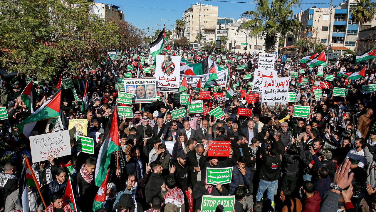 People wave Palestinian and Jordanian flags as they march during a demonstration near the US Embassy in solidarity with the people of Gaza, Amman, Jordan, Dec. 15, 2023.