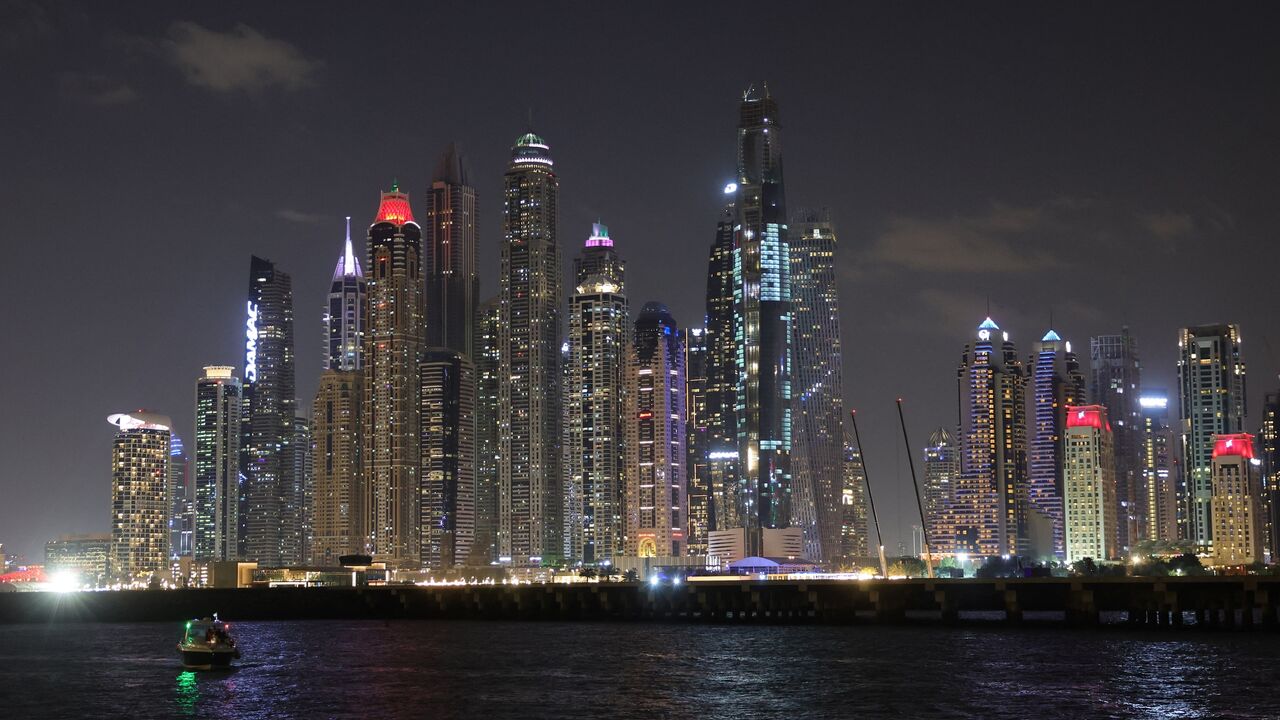 A boat sails at the Dubai marina with a view of the Gulf Emirate's skyline on Dec. 15, 2023.