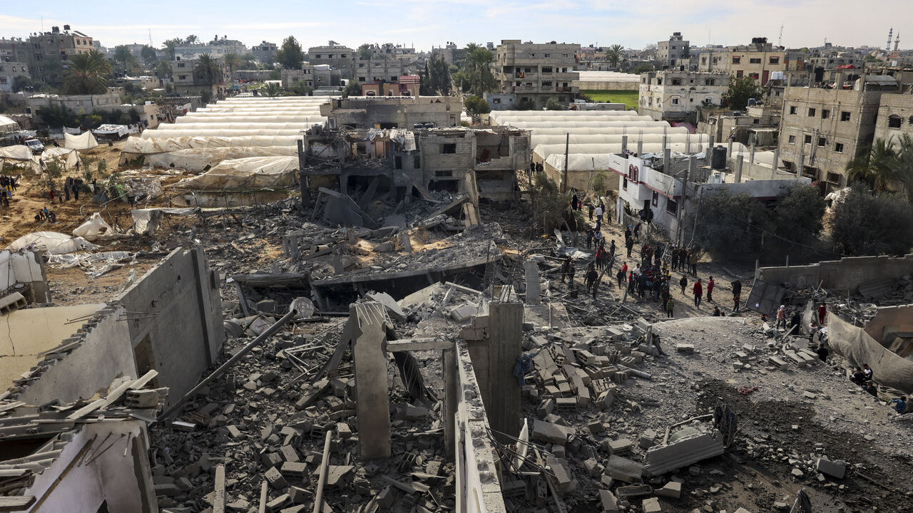 Palestinians inspect the damage amid the rubble of a building where two hostages were reportedly held before being rescued during an operation by Israeli security forcess in Rafah, on the southern Gaza Strip on February 12, 2024, amid ongoing battles between Israel and the militant group Hamas. Israel announced on February 12 the rescue of two hostages in the southern Gaza city of Rafah, where the Hamas-run health ministry said "around 100" Palestinians including children were killed in heavy overnight air