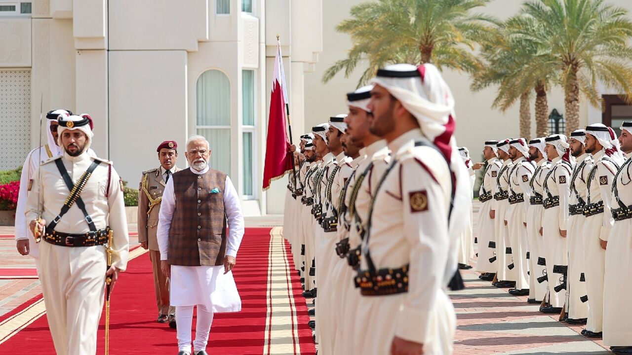 India's Prime Minister Narendra Modi inspects a Qatari guard of honour during a ceremonial reception in Doha