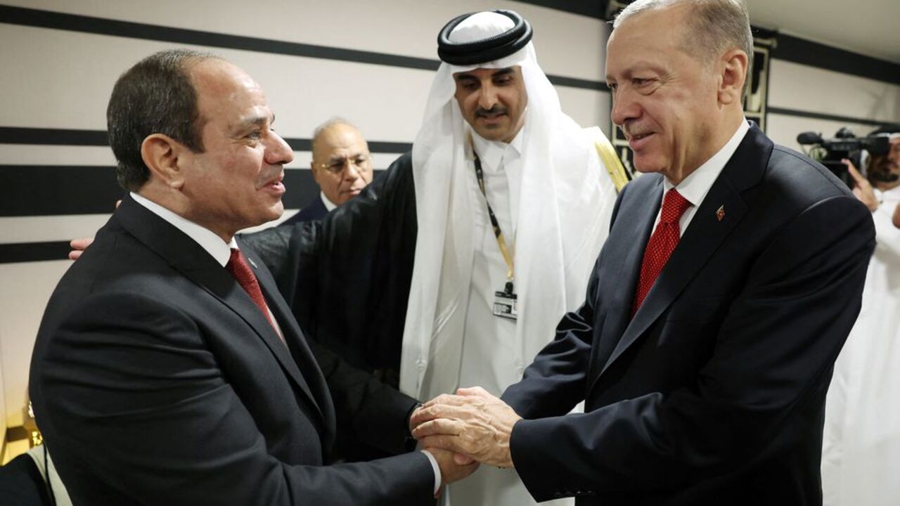 Turkish President Recep Tayyip Erdogan, right, shakes hands with his Egyptian counterpart, Abdel Fattah el-Sisi, as they are welcomed by Qatar's emir, Sheikh Tamim bin Hamad Al Thani, during the opening ceremony of the World Cup in Doha, Qatar on November 20, 2022 [Handout/Press Office of the Presidency of Turkey