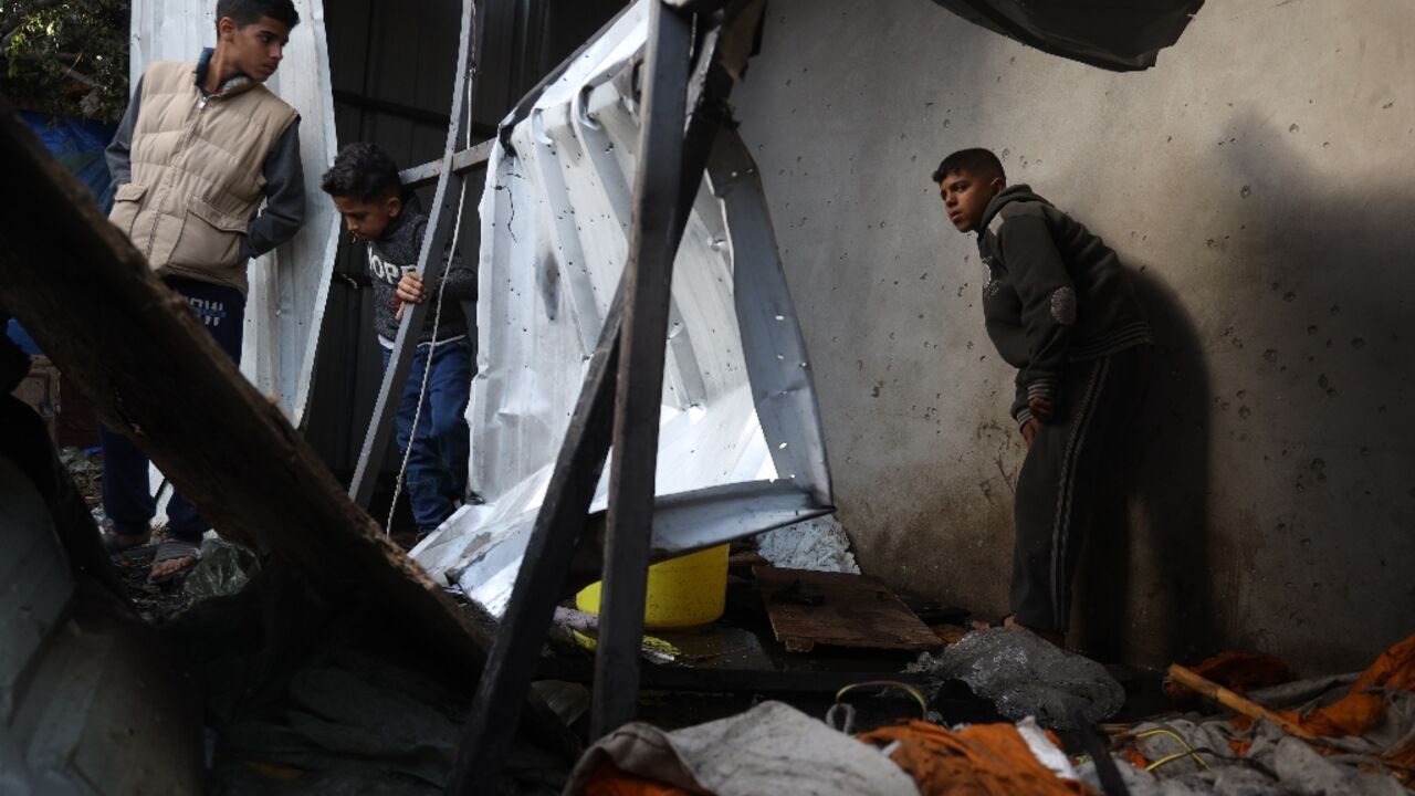 Children check the damage at a bombarded makeshift shelter near the Emirati hospital in Rafah Children check the damage at a bombarded makeshift shelter near the Emirati hospital in Rafah