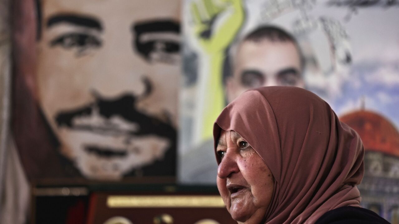 Latifa Abu Hamid, 74, sits near portraits of her children, at her house in Ramallah in the occupied West Bank