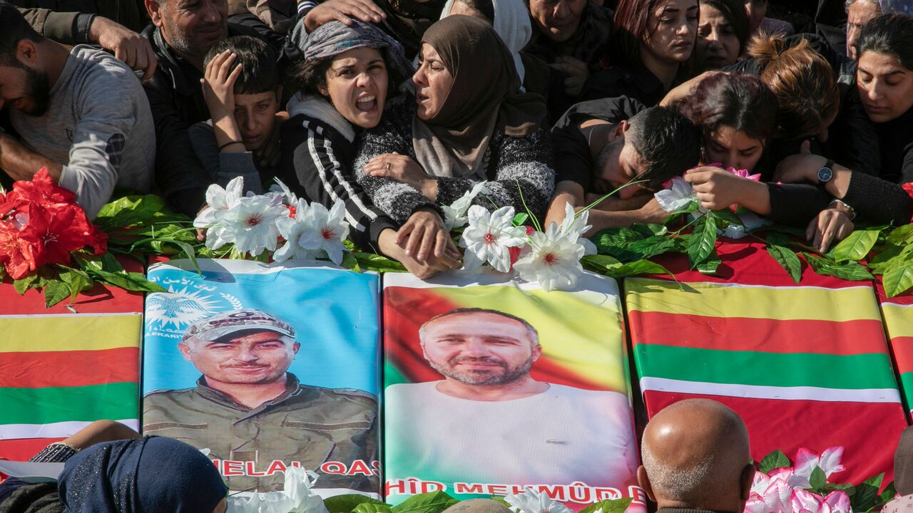 Relatives mourn over the caskets of 11 people killed in Turkish air strikes during their funeral in al-Malikiyah (Derik) in Syria's northeastern Hasakah province, on November 21, 2022. - Turkey hit dozens of targets in northern Syria as well as northern Iraq overnight into Sunday, a week after a deadly attack in Istanbul which Ankara has blamed on the Kurdistan Workers' Party (PKK). (Photo by Gihad DARWISH / AFP) (Photo by GIHAD DARWISH/AFP via Getty Images)