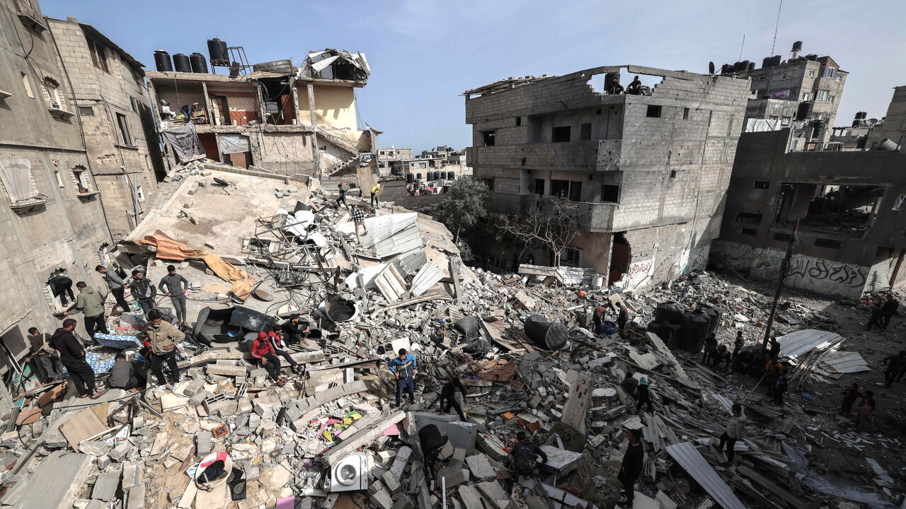 Palestinians check the rubble of buildings that were destroyed following overnight Israeli bombardment in Rafah, in the southern Gaza Strip, on March 27, 2024, amid the ongoing conflict between Israel and the Palestinian militant group Hamas. 