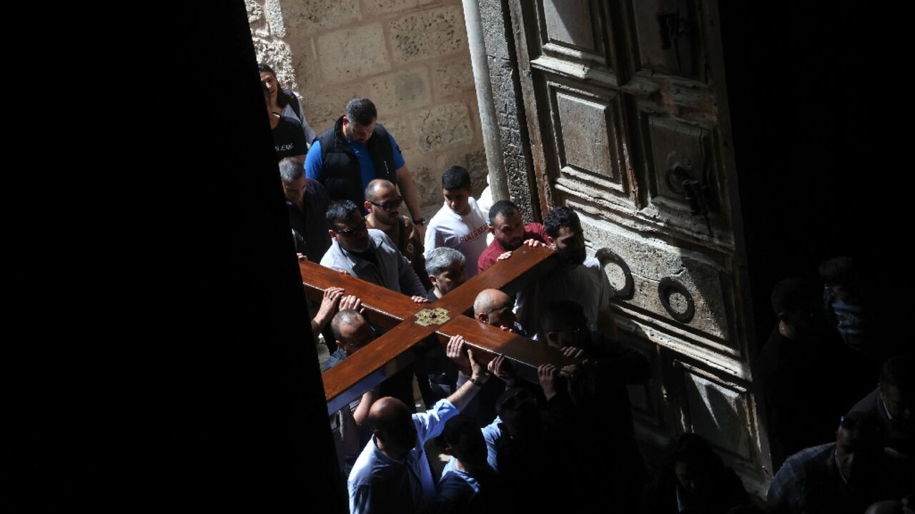 Christian pilgrims carry a wooden cross on the Good Friday procession through the streets of the Old City of Israeli-annexed east Jerusalem