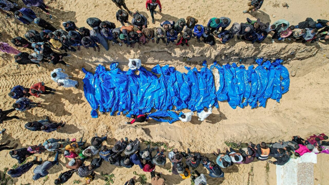 An aerial view of mourners looking on as medics prepare the 47 bodies for mass reburial