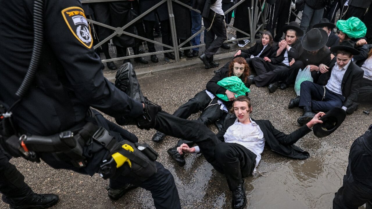 Israeli police officers try to remove ultra-Orthodox Jews protesting against defence ministry plans to end their longstanding exemption from  compulsory military service