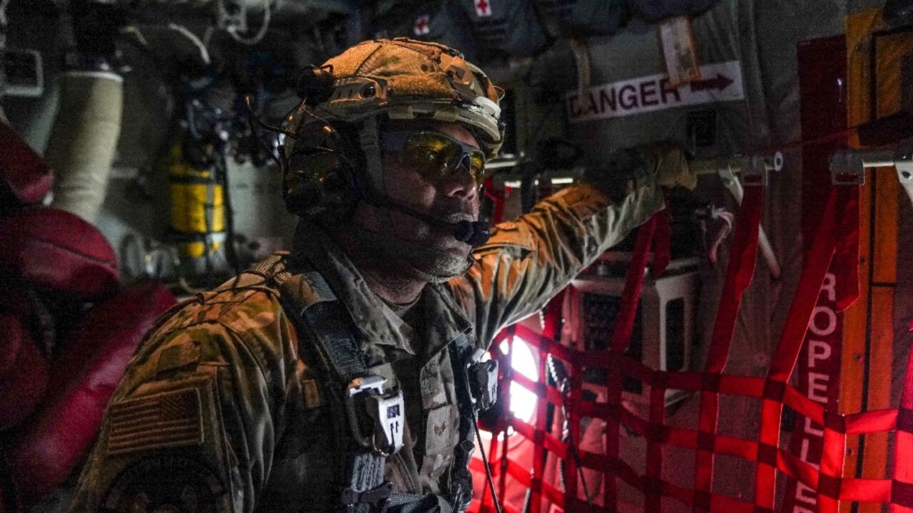 A member of the US Air Force 26th Expeditionary Rescue Squadron aboard an HC-130J aircraft prepares to airdrop humanitarian aid supplied by Jordan over the Gaza Strip