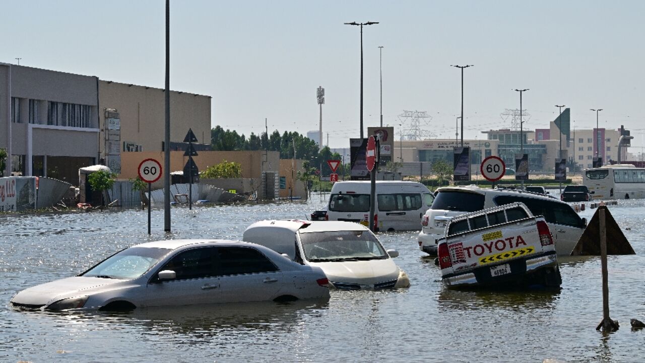 Waterlogged vehicles await recovery on a flooded Dubai highway Waterlogged vehicles await recovery on a flooded Dubai highway