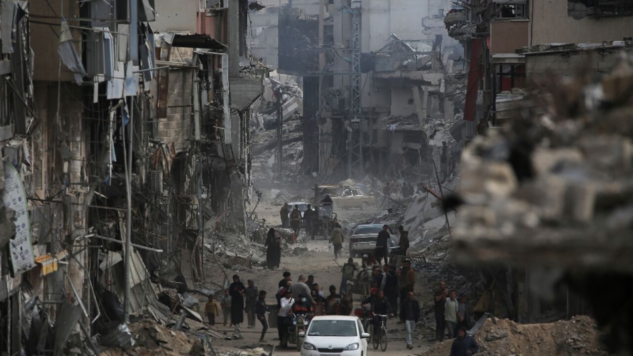 Palestinians walk back into the devastated remains of Khan Yunis in Gaza after the Israeli army withdrew