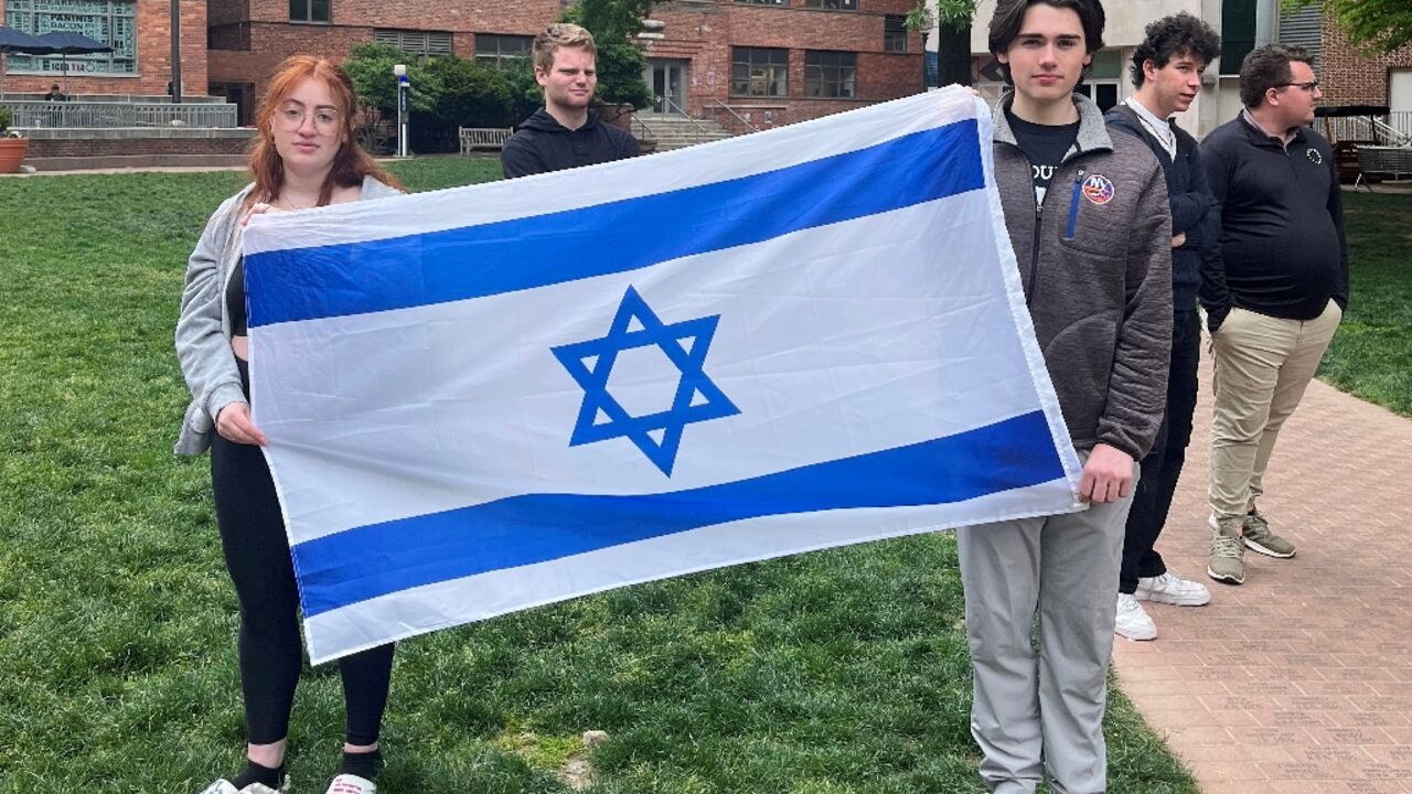 Philosophy student Skyler Sieradzky, 21, left, holds an Israeli flag as pro-Palestinian protesters stage a sit-in on the urban campus of George Washington University in Washington