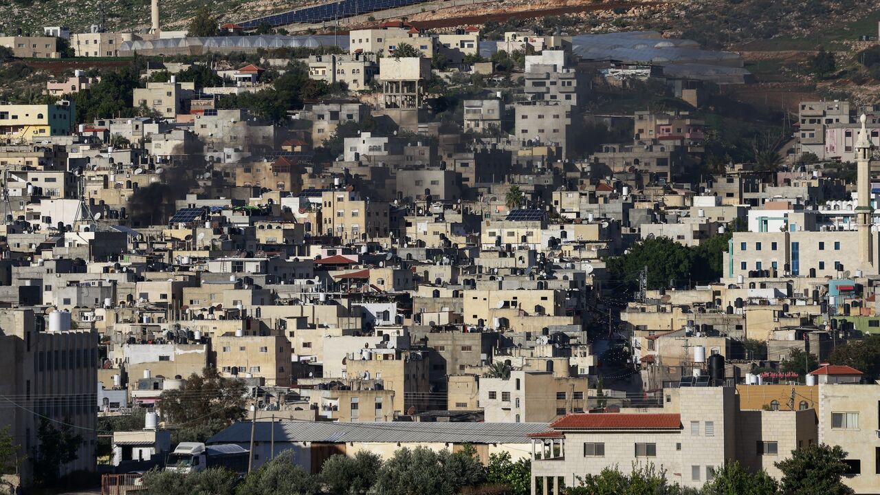 Black smoke billows amid clashes as Israeli forces raid the al-Faraa camp for Palestinian refugees near Tubas city in the occupied West Bank on Jan. 13, 2024.