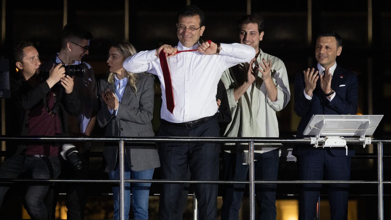 Ekrem Imamoglu, Istanbul mayor and the Republican People's Party (CHP) candidate, takes off his tie from atop a campaign bus while claiming victory surrounded by family members on April 1, 2024 in Istanbul, Turkey.