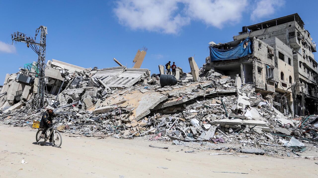People inspect damage and remove items from their homes following Israeli airstrikes on April 13, 2024 in Khan Yunis, Gaza.