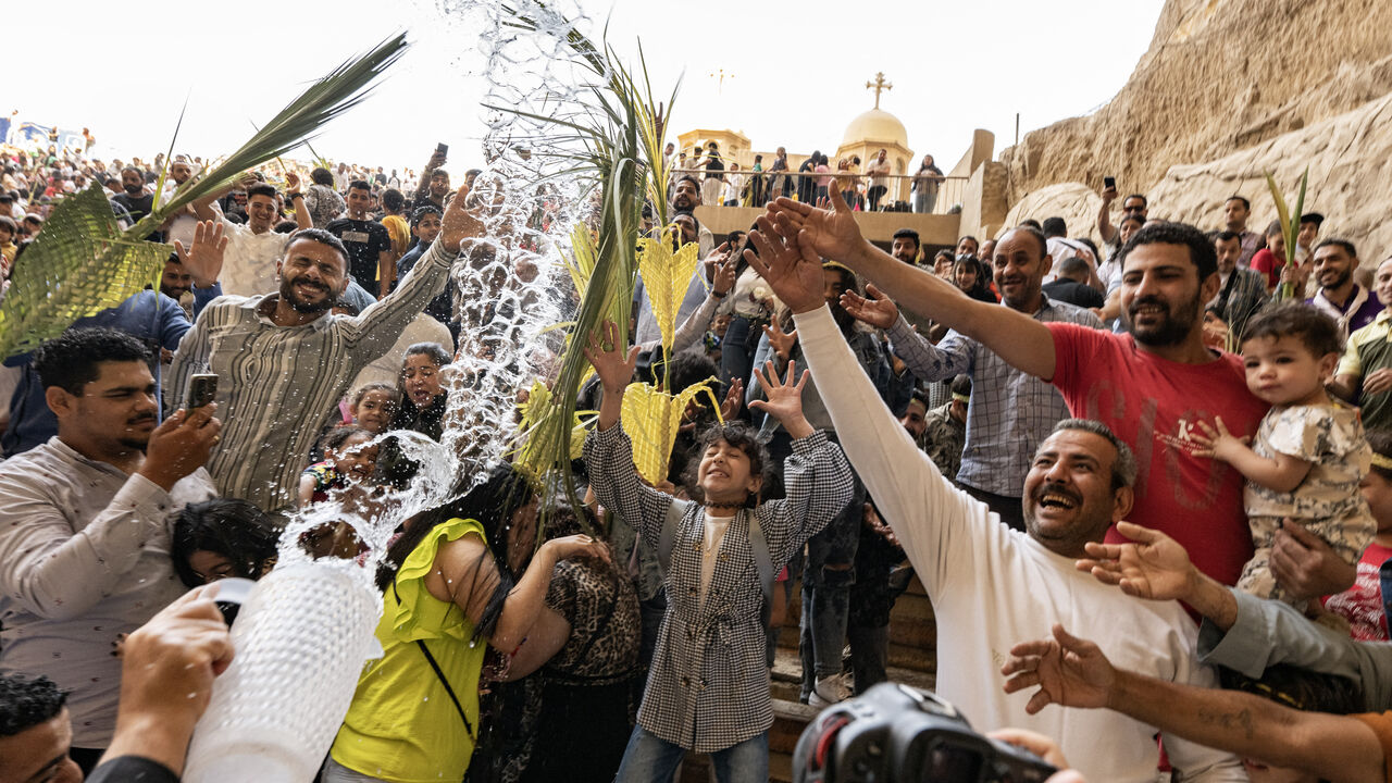 Christian worshippers are sprinkled with holy water during the Palm Sunday service, marking the start of Holy Week for Orthodox Christians, at the Coptic Orthodox Monastery of Simon the Tanner, also known as the Cave Church, in the eastern hillside Mokkatam district of Cairo on April 28, 2024. (Photo by Khaled DESOUKI / AFP) (Photo by KHALED DESOUKI/AFP via Getty Images)