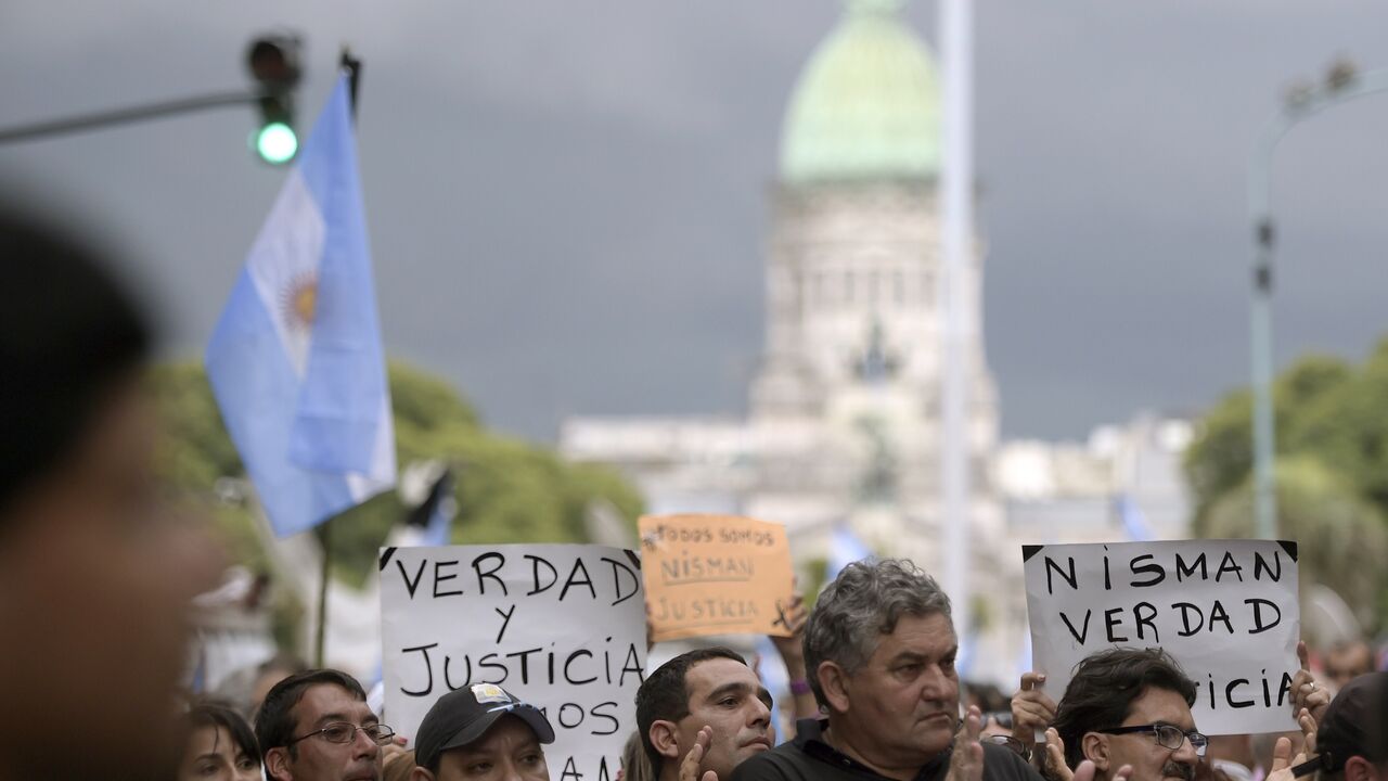 People rally near the Congress building before marching along Avenida de Mayo avenue in the "Marcha del silencio"(March of Silence) called by Argentine prosecutors in memory of their late colleague Alberto Nisman in Buenos Aires on February 18, 2015. President Cristina Kirchner urged Argentines to be on guard Wednesday ahead of a mass protest over the mysterious death of Nisman who had accused her of a cover-up in his probe of a 1994 bombing. Nisman was found in his Buenos Aires apartment with a bullet thro