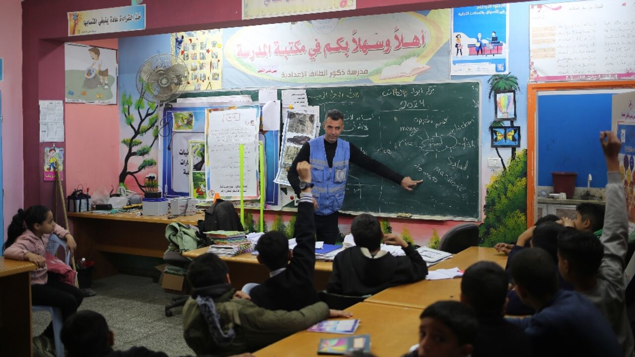 Ismail Wahba, director of the UNRWA Taif School in Rafah, teaches an English class in the library of a school housing displaced Palestinians in Rafah